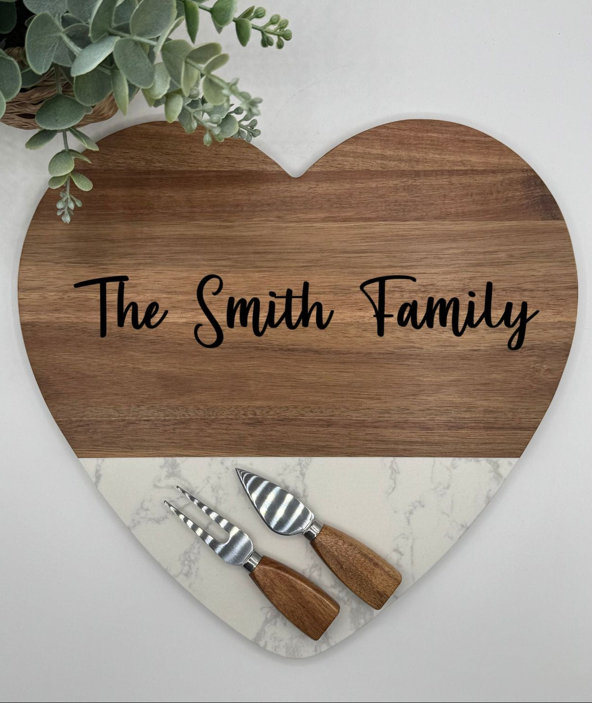 Personalized heart shaped marble charcuterie board set with utensils.