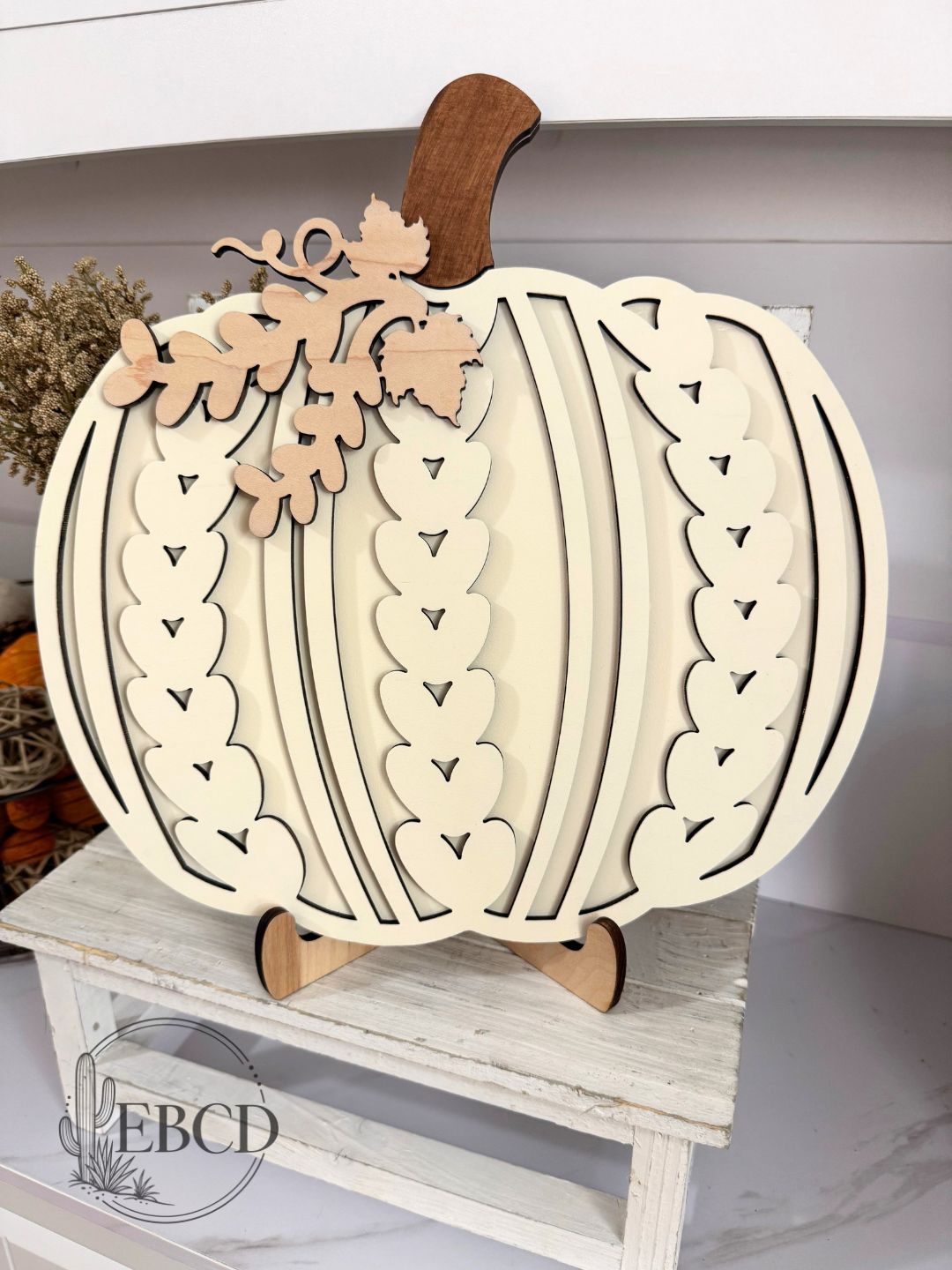 Hand painted Sweater Pumpkin fall decor with layered wood details, natural wood stem and leaf accents.