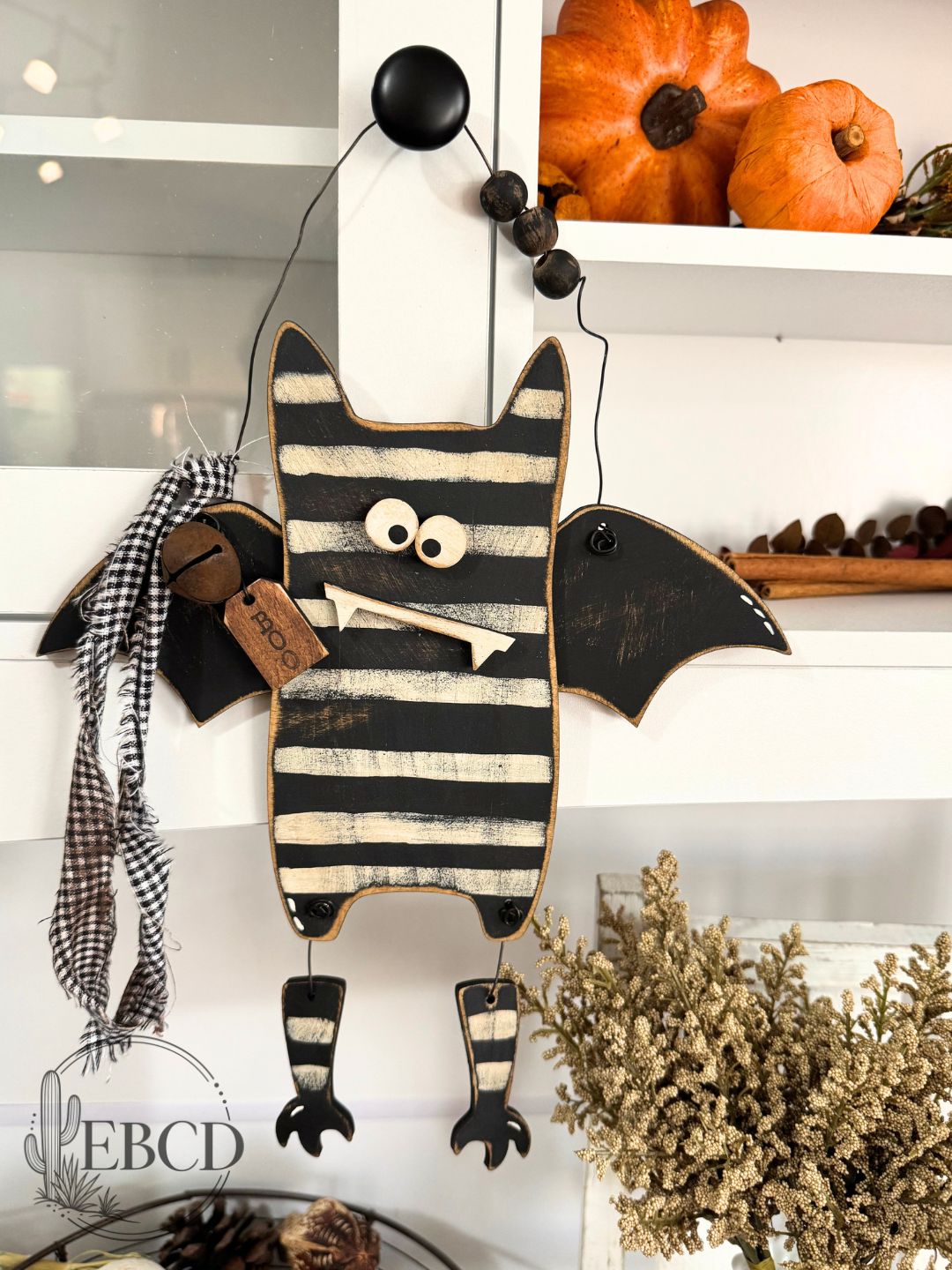 Hand painted Halloween bat decor with dangling legs, wood beads, fabric accents and BOO tag.