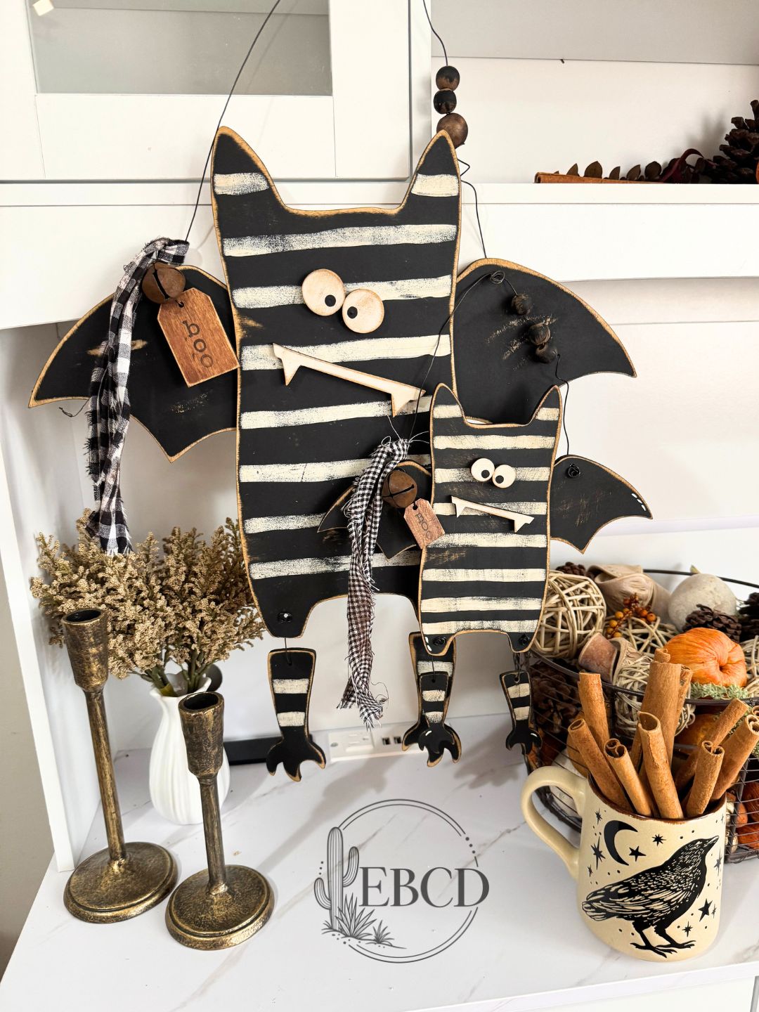 Hand painted Halloween bat decor with dangling legs, wood beads, fabric accents and BOO tag.