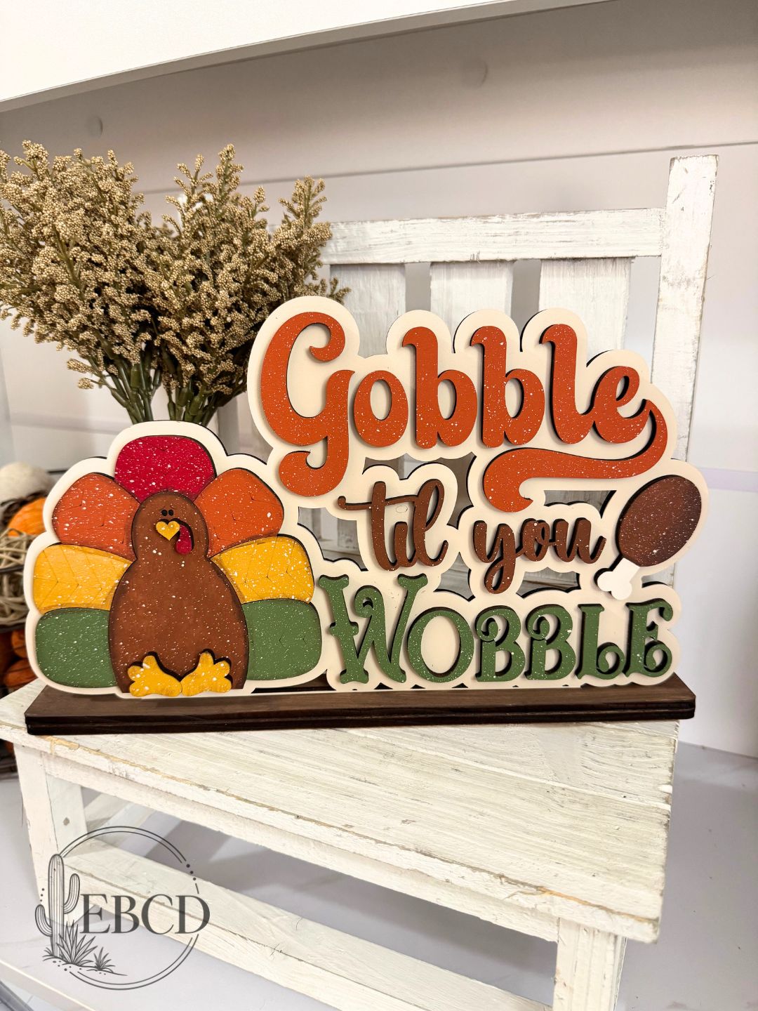 Hand painted Thanksgiving turkey shelf sitter decor with colorful layered Gobble Til You Wobble lettering.